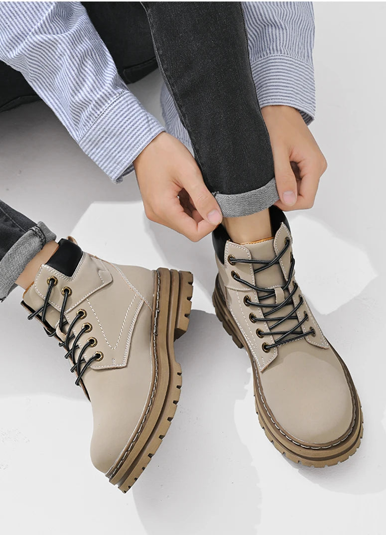 Person wearing beige boots with black laces on a white background